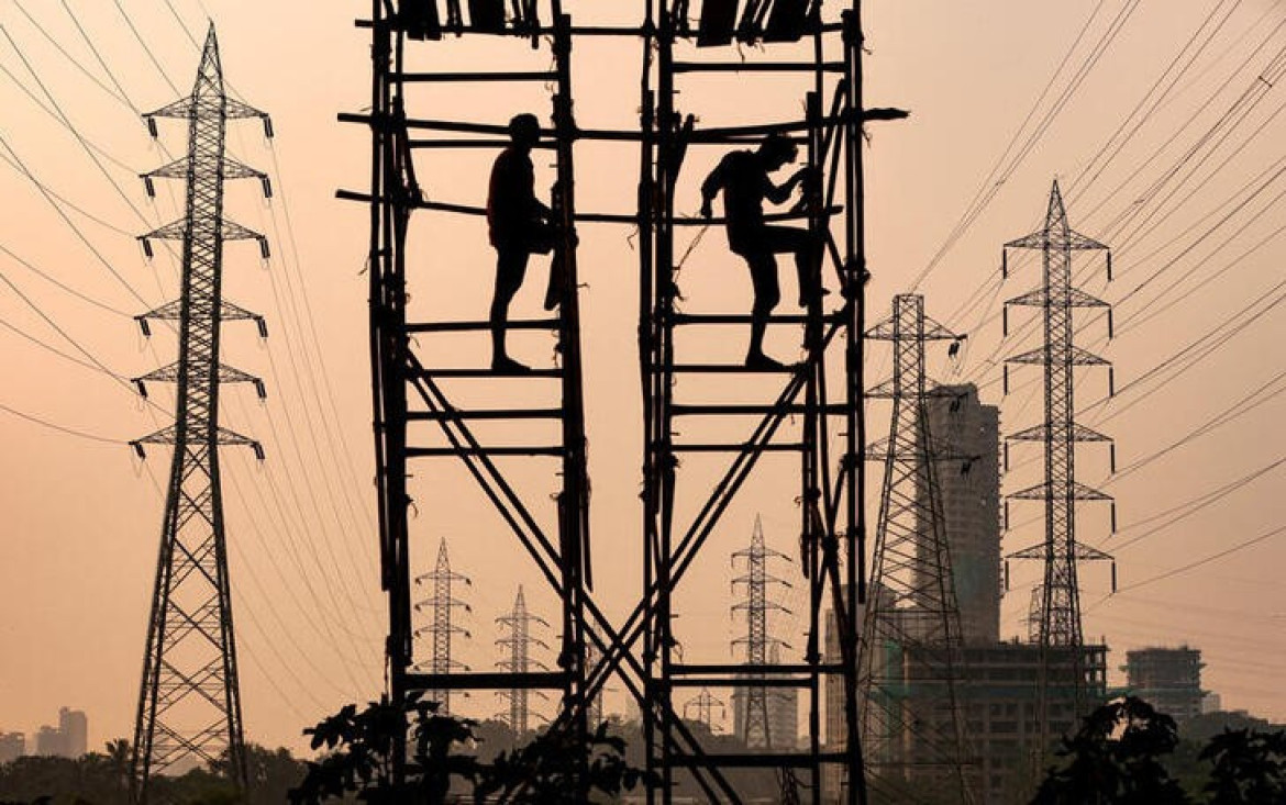 Personas trabajando en torres eléctricas en Mumbai, India. Reuters