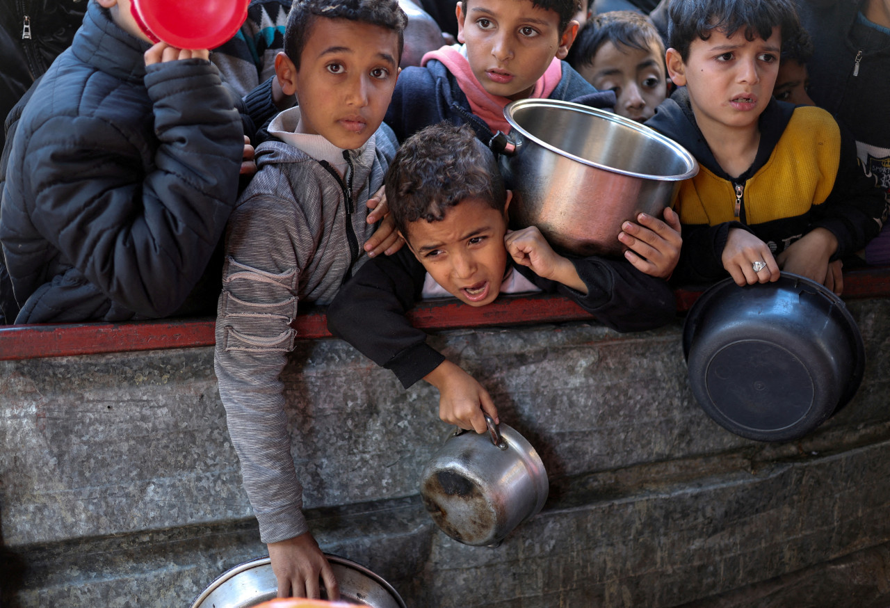 El hambre como "arma de guerra". Niños esperando comida en Gaza. Reuters