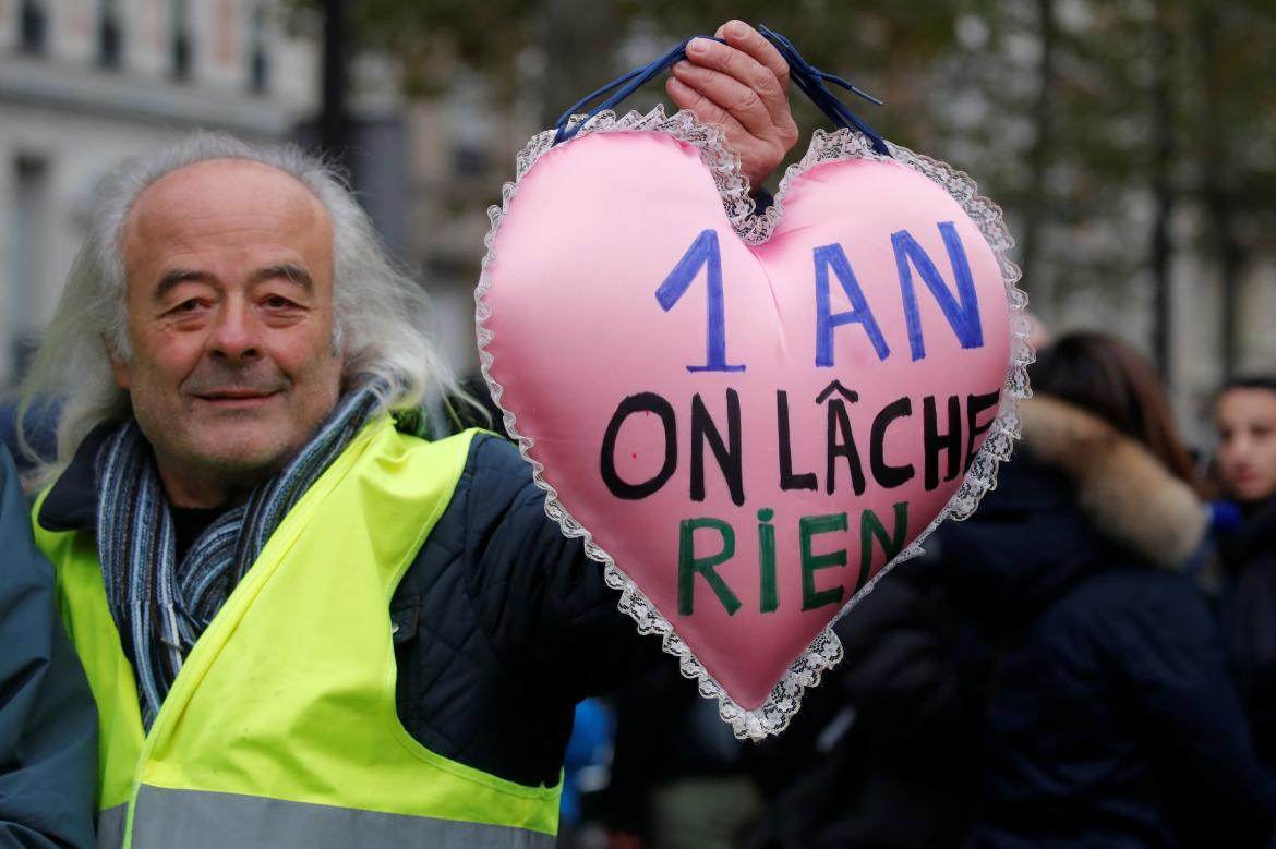 Un manifestante sostiene una almohada en forma de corazón con el lema 