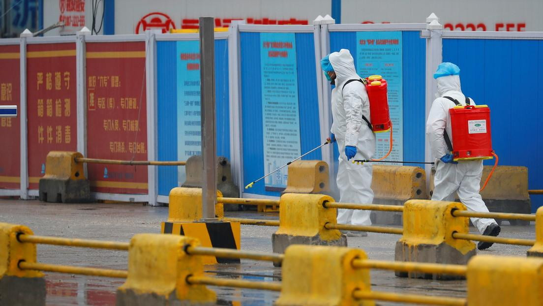 Trabajadores desinfectan el territorio de un mercado, Wuhan, China, el 31 de enero de 2021, Reuters