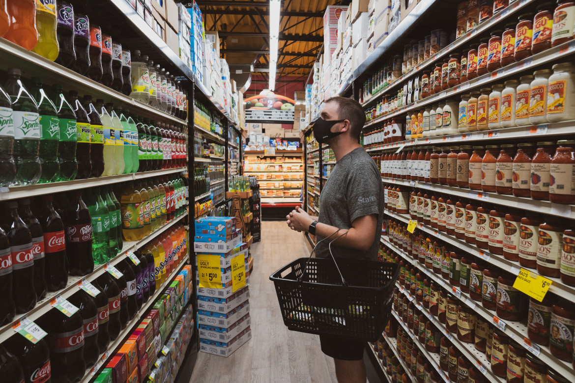 Usuario eligiendo bebidas, supermercado. Foto: Unsplash