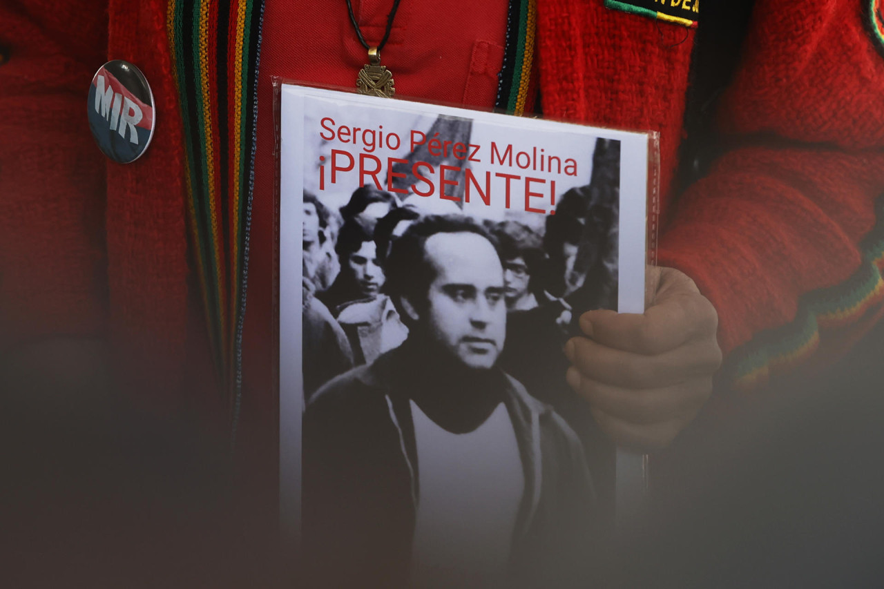 Una persona sostiene la fotografía de una persona desaparecida durante la dictadura de Augusto Pinochet. Foto: EFE.