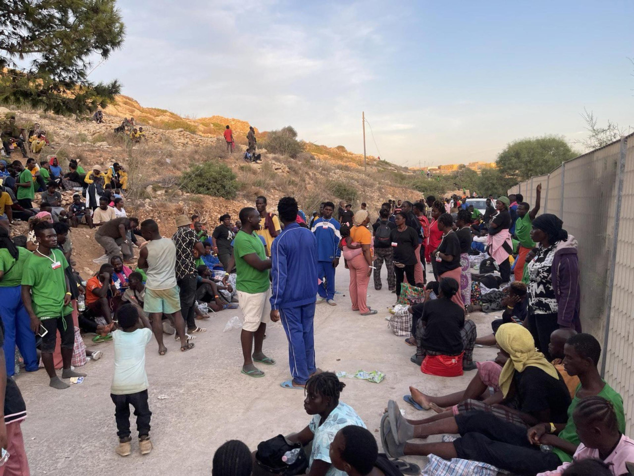 Un grupo de migrantes espera en la isla de Lampedusa. Foto: EFE
