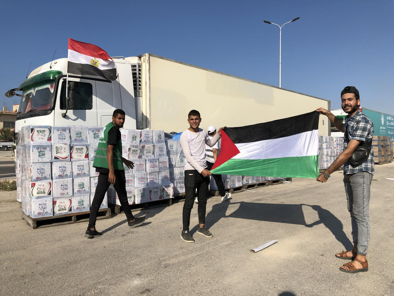 Banderas palestinas y egipcias frente a un convoy de ayuda humanitaria para la Franja, en Egipto. Foto: EFE
