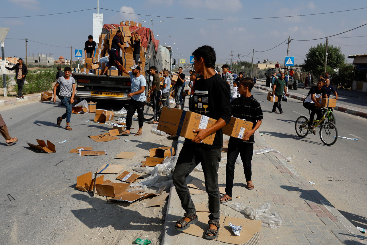 Palestinos recibiendo paquetes de ayuda humanitaria. Gaza. Reuters.