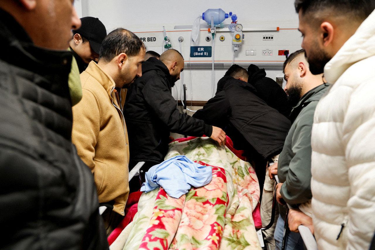Personas alrededor de los cuerpos asesinados en la operación israelí. Foto: Reuters.